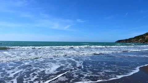 Ocean waves hitting sandy beach under bright blue tropical sky Stock Footage 310243260