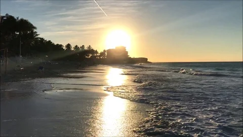 Ocean waves hitting a tropical sandy beach during a sunset Stock Footage 104124773