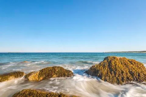 Ocean waves lash line impact rock on the beach Stock Photos