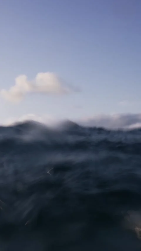 Ocean Waves with Mountainous Island in the Background at Dawn Stockbeeldmateriaal 335197638