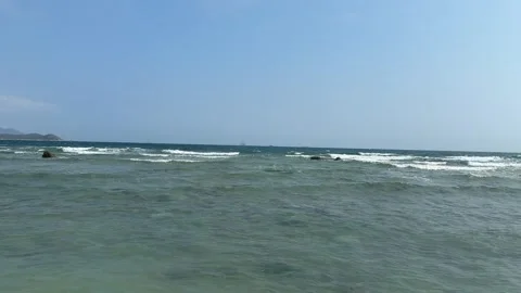 Ocean Waves with Offshore Platform in Distance under Blue Sky Video stock 330840144