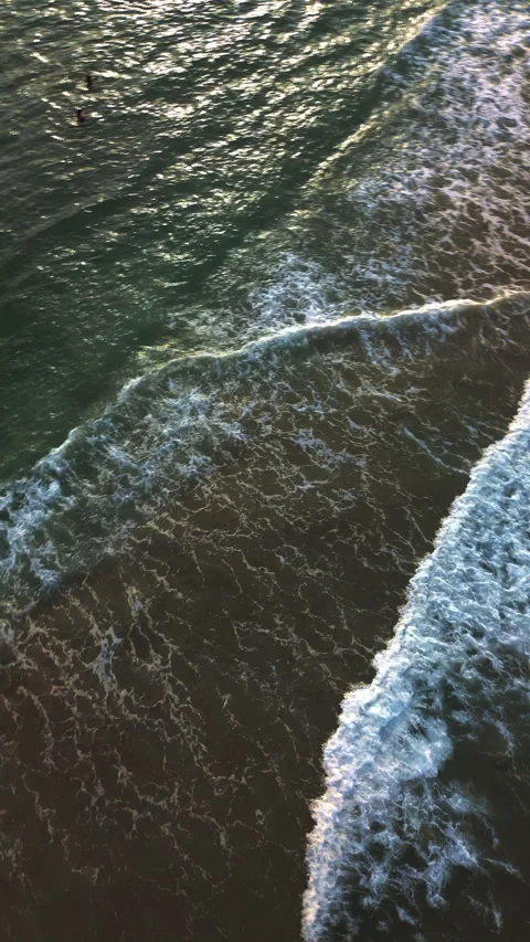 Ocean waves reaching the shore at sunset with calm coastal texture Stock Footage 341994234