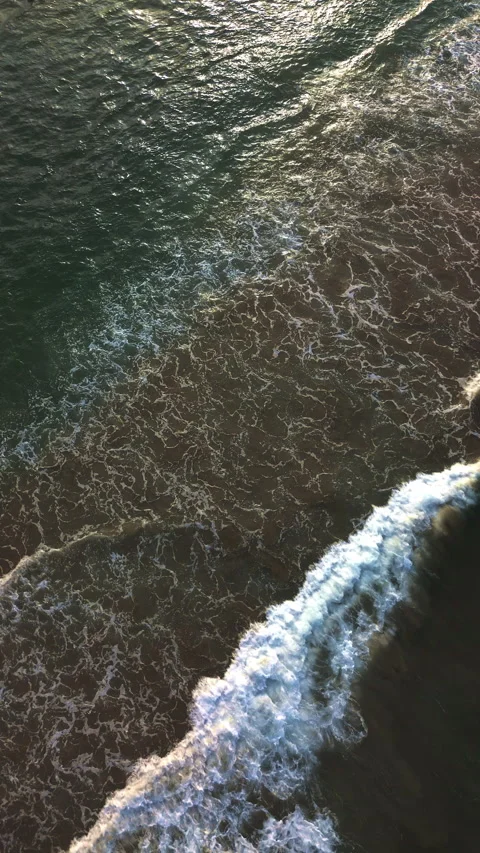Ocean waves reaching the shore at sunset with calm coastal texture Stock Footage 341994492
