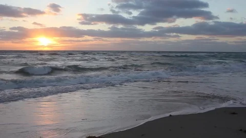 Ocean waves with a reflecting sunset in the background Stock Footage 93782242
