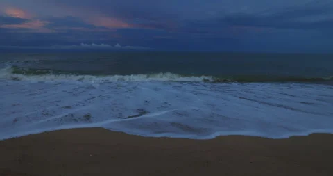 The ocean waves roll break on sand beach in the dark night. Stock Footage 254449461