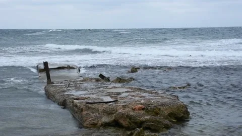 Ocean waves roll over the concrete pier. 動画素材 180863755