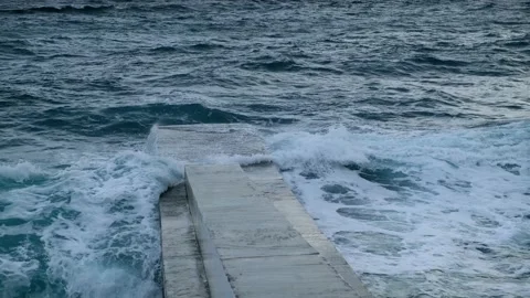 Ocean waves roll over the concrete pier Stock Footage 184573790