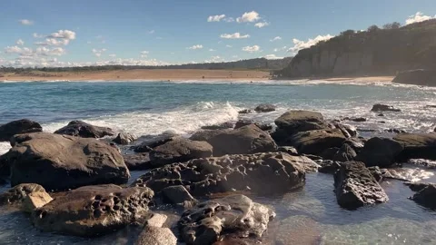 Ocean waves roll into the rocks and beach Stock Footage 250726191