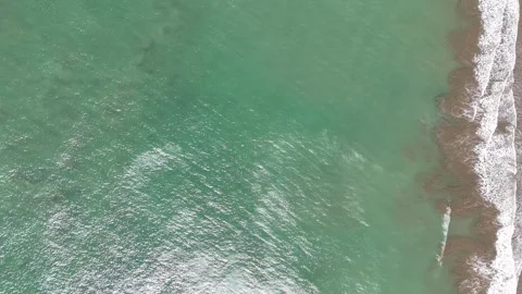 Ocean waves roll onto the shore at a sunny beach location today Video stock 329188519