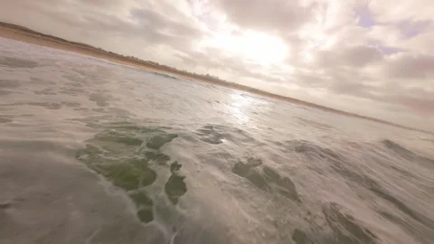 Ocean waves roll toward beach under dramatic clouds Stock Footage 345149568