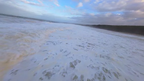 Ocean waves roll toward shore with frothy white crests Video stock 344675739