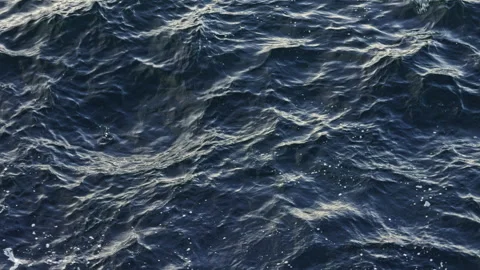Ocean waves rolling across dark water 動画素材 338293092