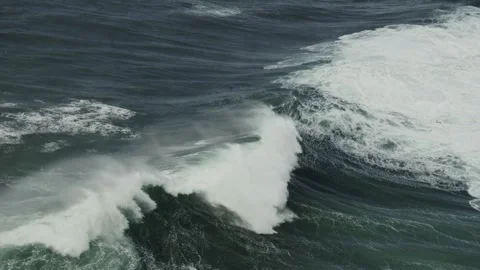Ocean waves rolling and breaking along a rugged coastline Видео 345676822