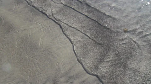 Ocean waves rolling up onto the beach slowly with one quick wave at end 스톡 동영상 33718486