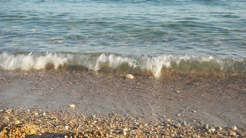 Ocean waves rolling into rocky shore at sunset Stock Footage 97612456
