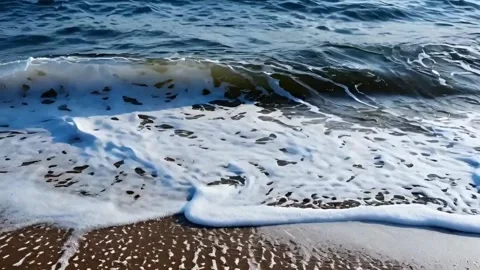 Ocean waves rolling into sandy beach creating sea foam during daytime in co.. Stock Footage 321948541
