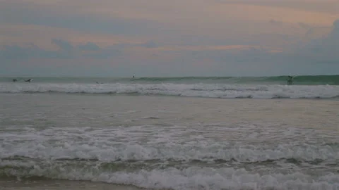 Ocean waves rolling onto sandy shore under colorful evening sky, Video stock 285871018