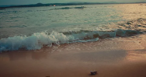 Ocean waves rolling onto a smooth sandy beach during sunset. Stock Footage 342469701