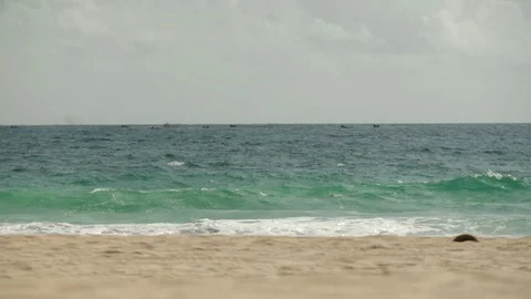 Ocean waves rushing towards beach on a sunny day Stock Footage 117742220