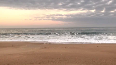 Ocean waves on a sandy beach. A flock of gulls flies in the frame. Stock Footage 87495285
