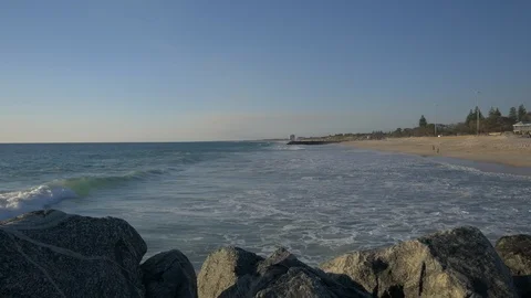 Ocean waves sandy beach looking up the coast in the afternoon Stock Footage 94457141