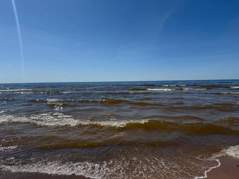 Ocean Waves on Sandy Beach Under Clear Blue Sky Stock Photos