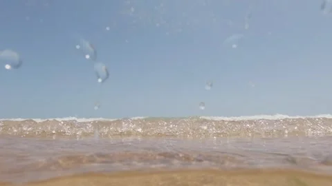 Ocean waves on shore from underwater. Camera submerges and surfaces, showin.. Stock Footage 279548638