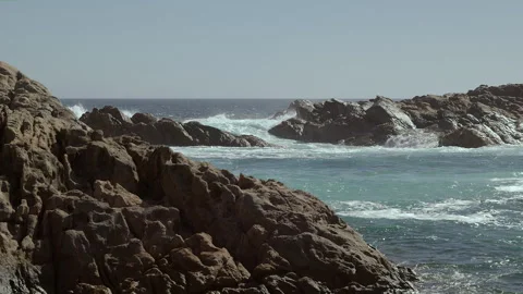 Ocean waves slam into rocks which flank a natural canal. Sound of turbulence. Stock Footage 344751431