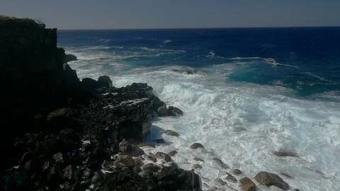 Ocean waves slam into a sea cliff sending spray high into the air Stock Footage 84894455