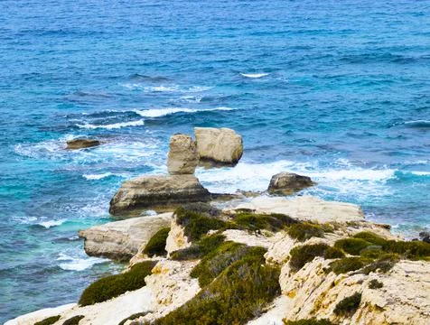 Ocean waves splash against beach with rocks background, Cliffs in the sea Stock Photos