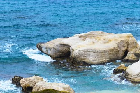 Ocean waves splash against beach with rocks background, Cliffs in the sea Stock Photos