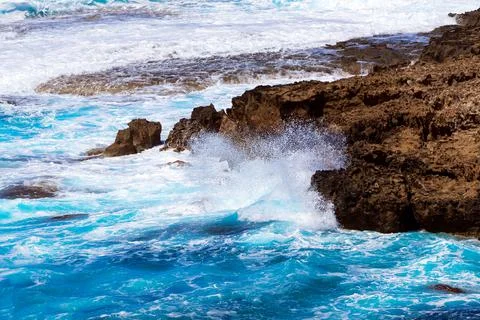 Ocean waves splash against beach with rocks background, Cliffs in the sea Stock Photos