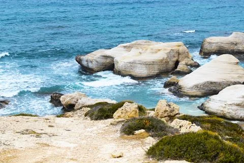 Ocean waves splash against beach with rocks background, Cliffs in the sea Stock Photos