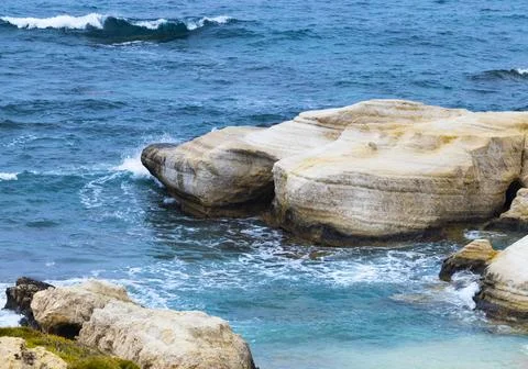Ocean waves splash against beach with rocks background, Cliffs in the sea Stock Photos