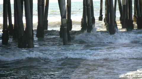 Ocean waves splash against the pier's support columns (High Definition) Stock Footage 360080