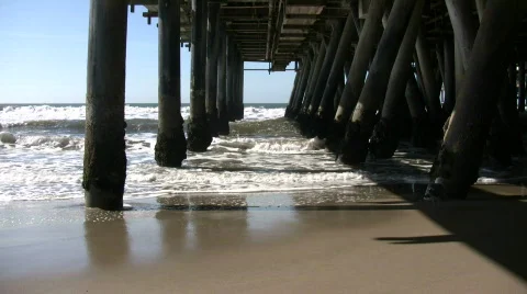 Ocean waves splash against the pier's support columns (High Definition) Stock Footage 360085