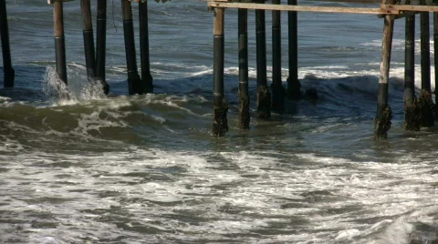 Ocean waves splash against the pier's support columns (High Definition) Stock Footage 360089