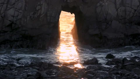 Ocean waves splash through keyhole rock formation sea stack at Pfifer Beach Stock Footage 169402711