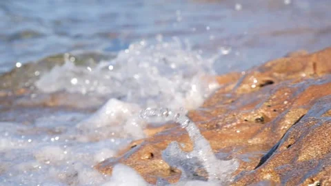 Ocean waves splash white foam over wet rocks along shore Stock Footage 337411024
