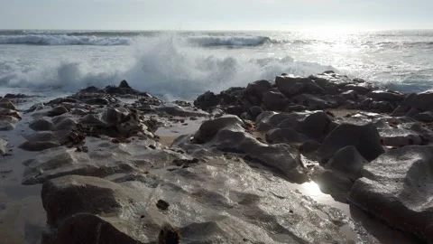Ocean waves splashing against rocks on beach in slow motion Stock Footage 194202889