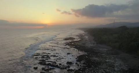 Ocean waves splashing on black reef on wild beach in tropical paradise. Stock Footage 247396123