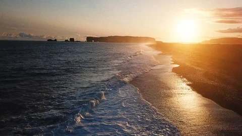 Ocean waves at sunset on black sand beach in Iceland, aerial landscape by drone Stock Footage 98156526