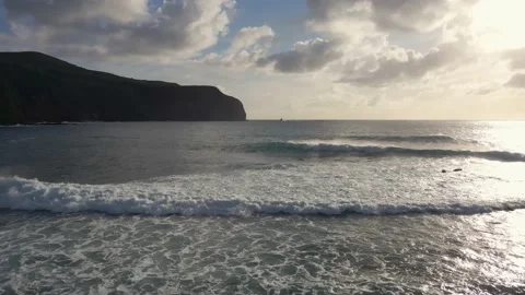 Ocean waves at sunset with a cliff in the background Stock Footage 195333125
