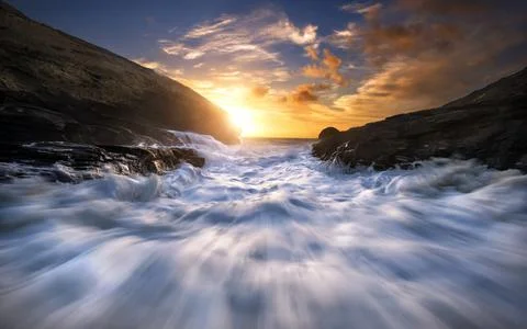 Ocean Waves at Sunset on a Dramatic Rocky Coast Stock Photos