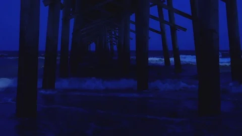Ocean Waves Under a Dark Pier Stock Footage 76506009