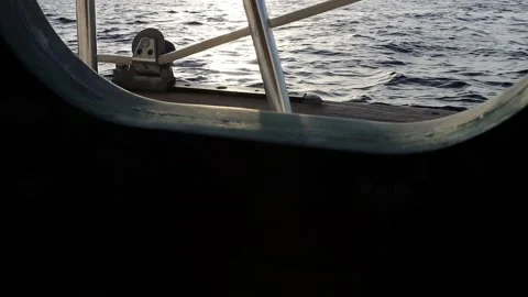 Ocean waves viewed through a bronze porthole of a sailboat Stock Footage 160380480