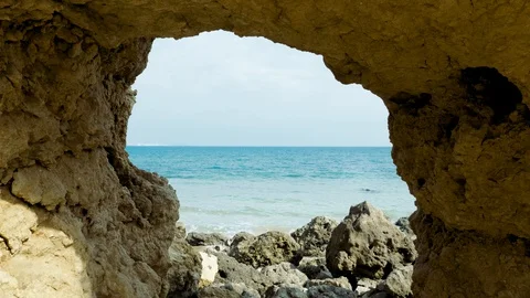 Ocean waves viewed through rock arch Video stock 128396484