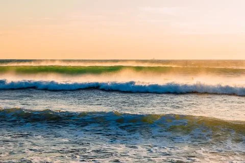 Ocean waves at warm sunset or sunrise. Waves and wind with evening light Stock Photos