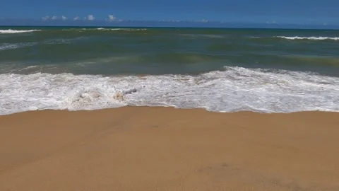 Ocean waves wash over sand beach along the eastern shore of Madagascar Stock Footage 310534359