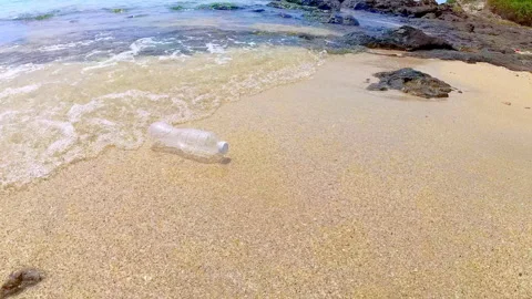 Ocean waves washed plastic bottle up on the shore. Video stock 284948175
